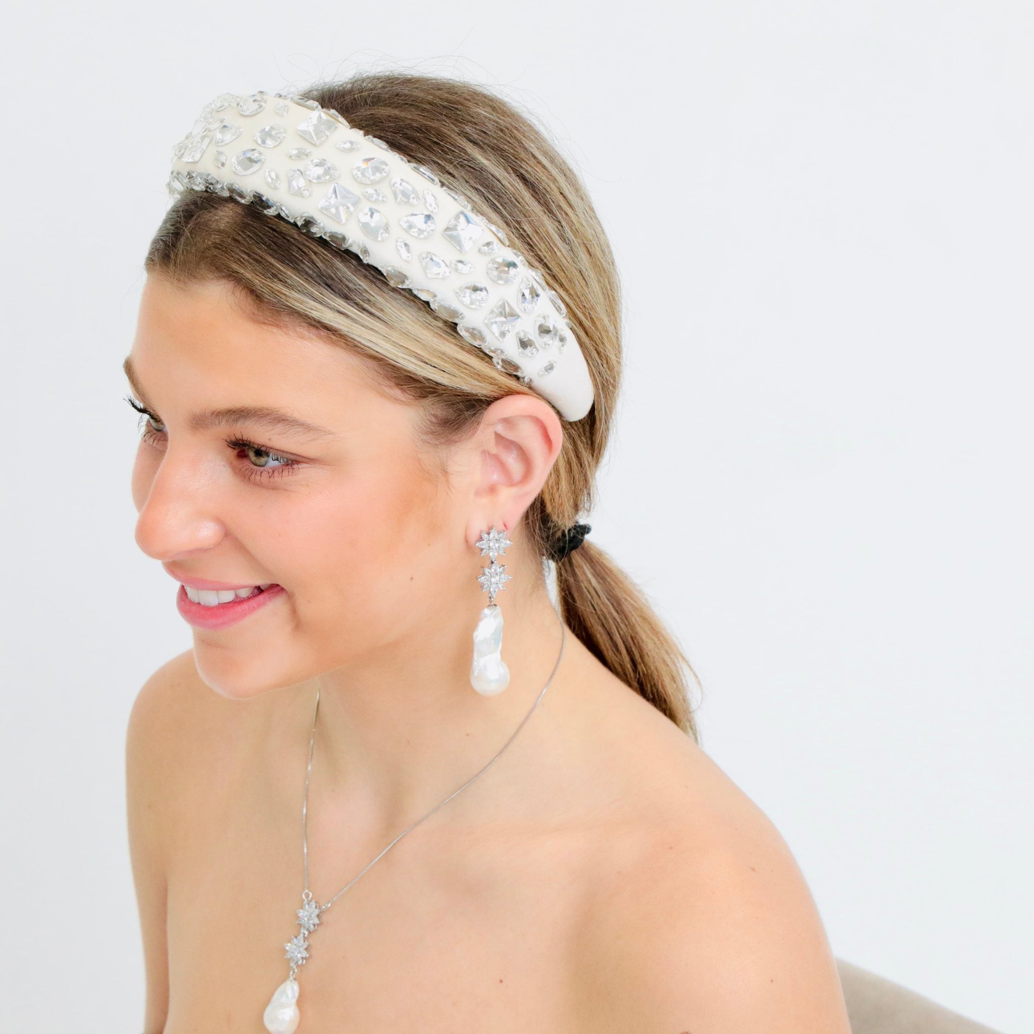 Crystal-adorned white headband, a radiant bridal headband that enhances elegance and charm.