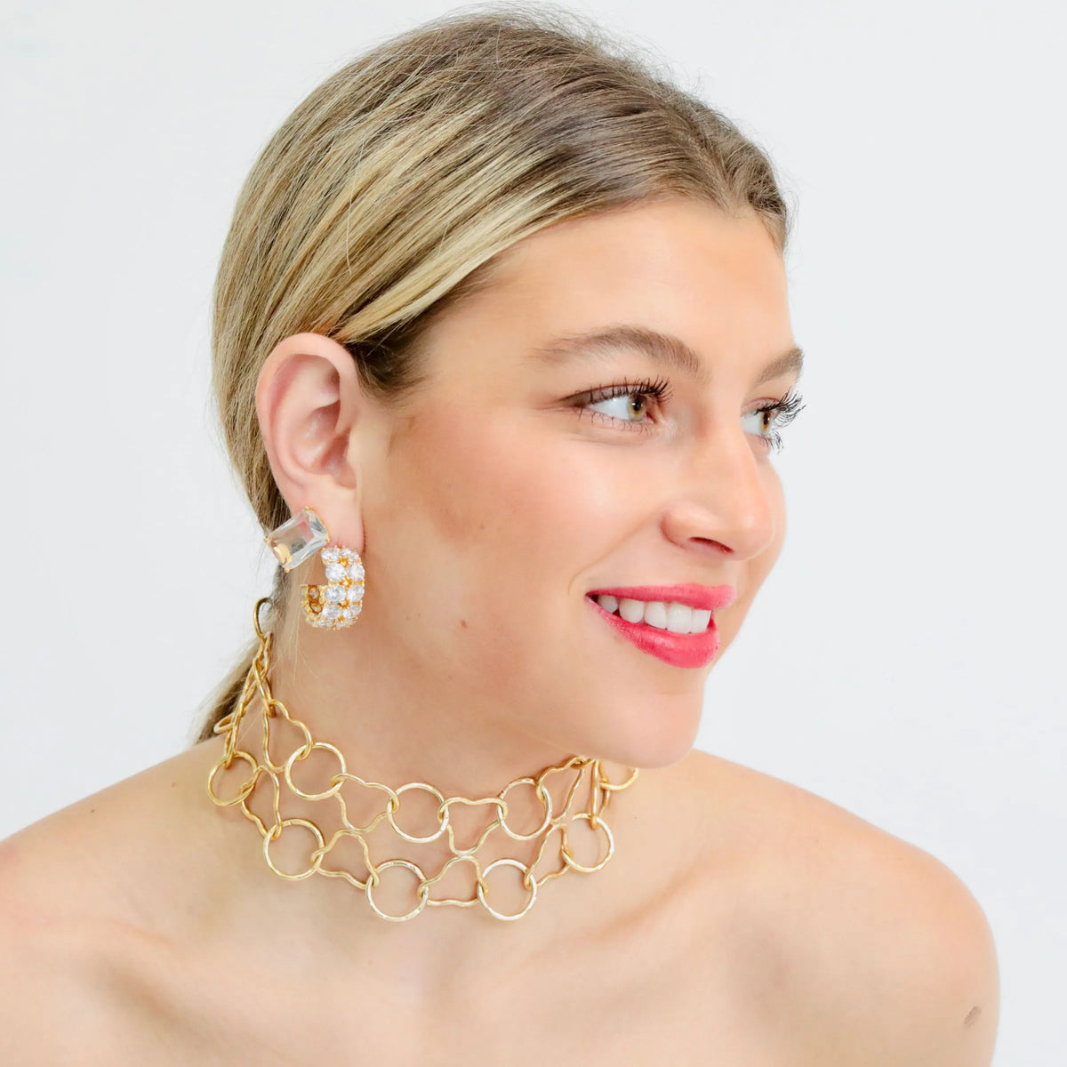 Gold hoop earrings with cubic zirconia worn on the ear
