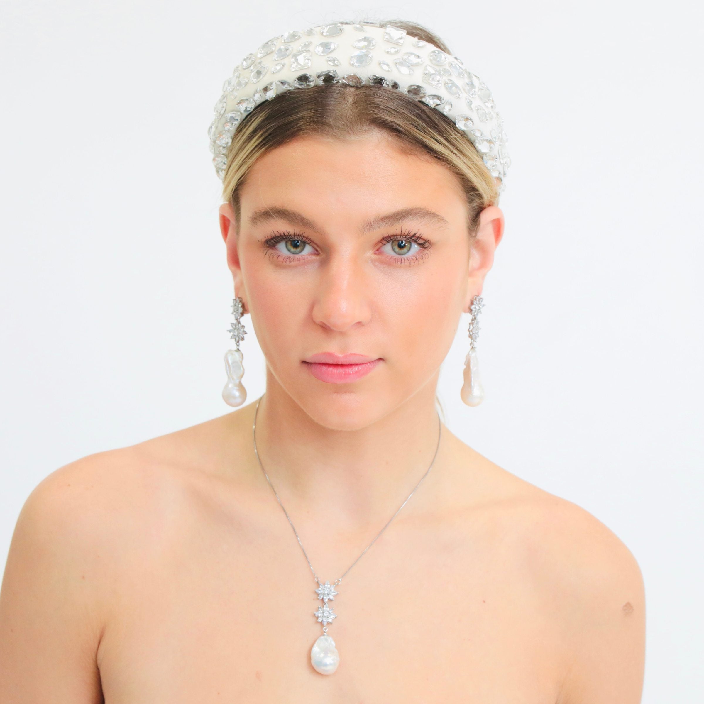 This pearl flower necklace, designed in NYC, is shown here with its matching pearl earrings as part of a complete set.