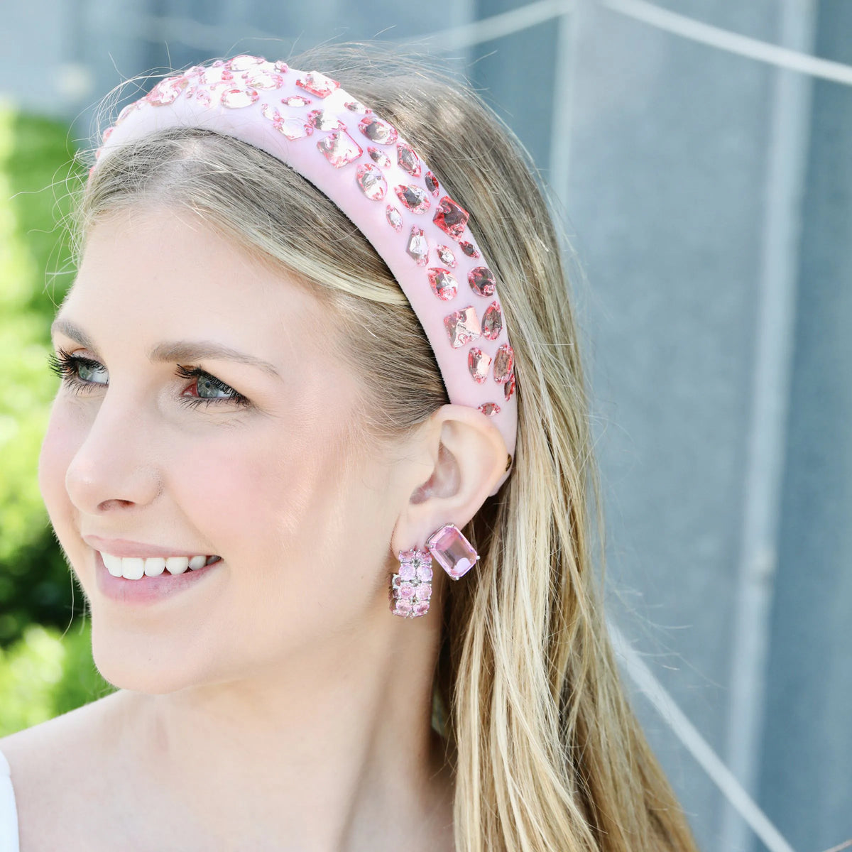 Pink drop earrings worn on the ear