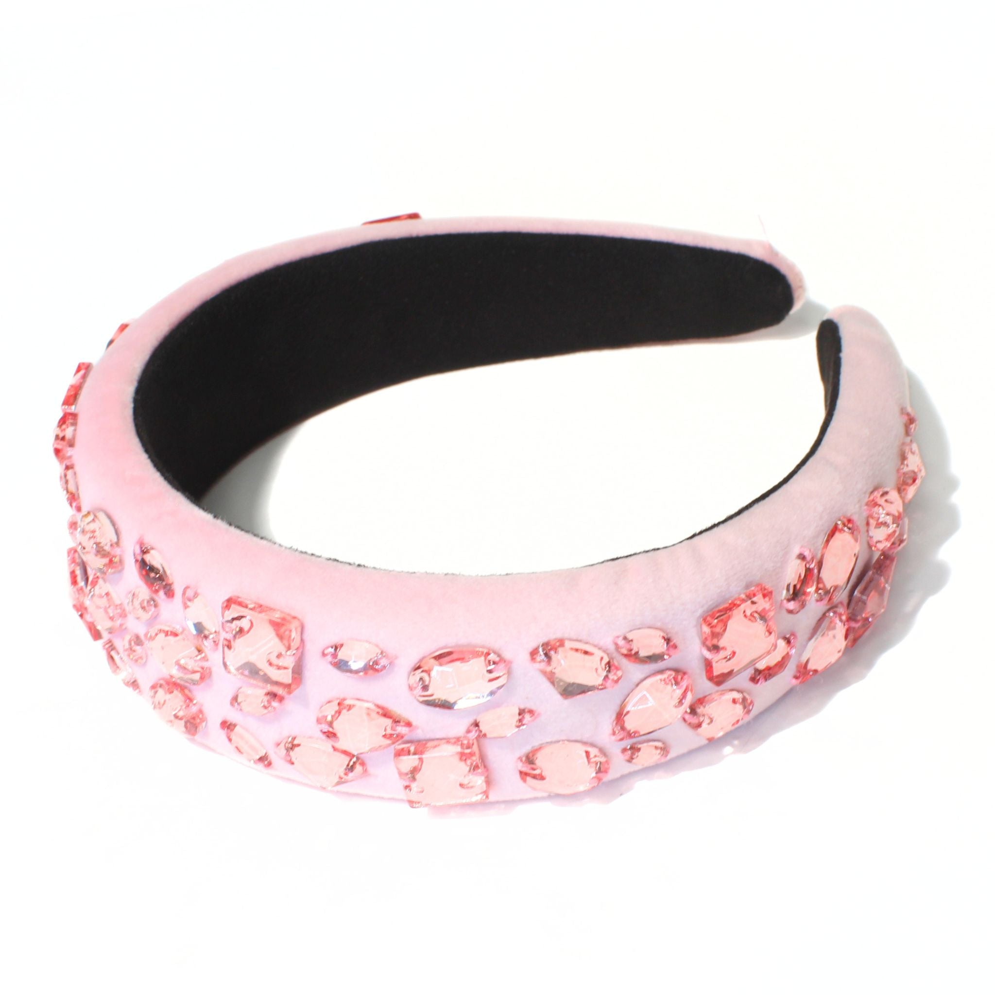 A pink hair band set with around sixty crystals, worn back off the face.