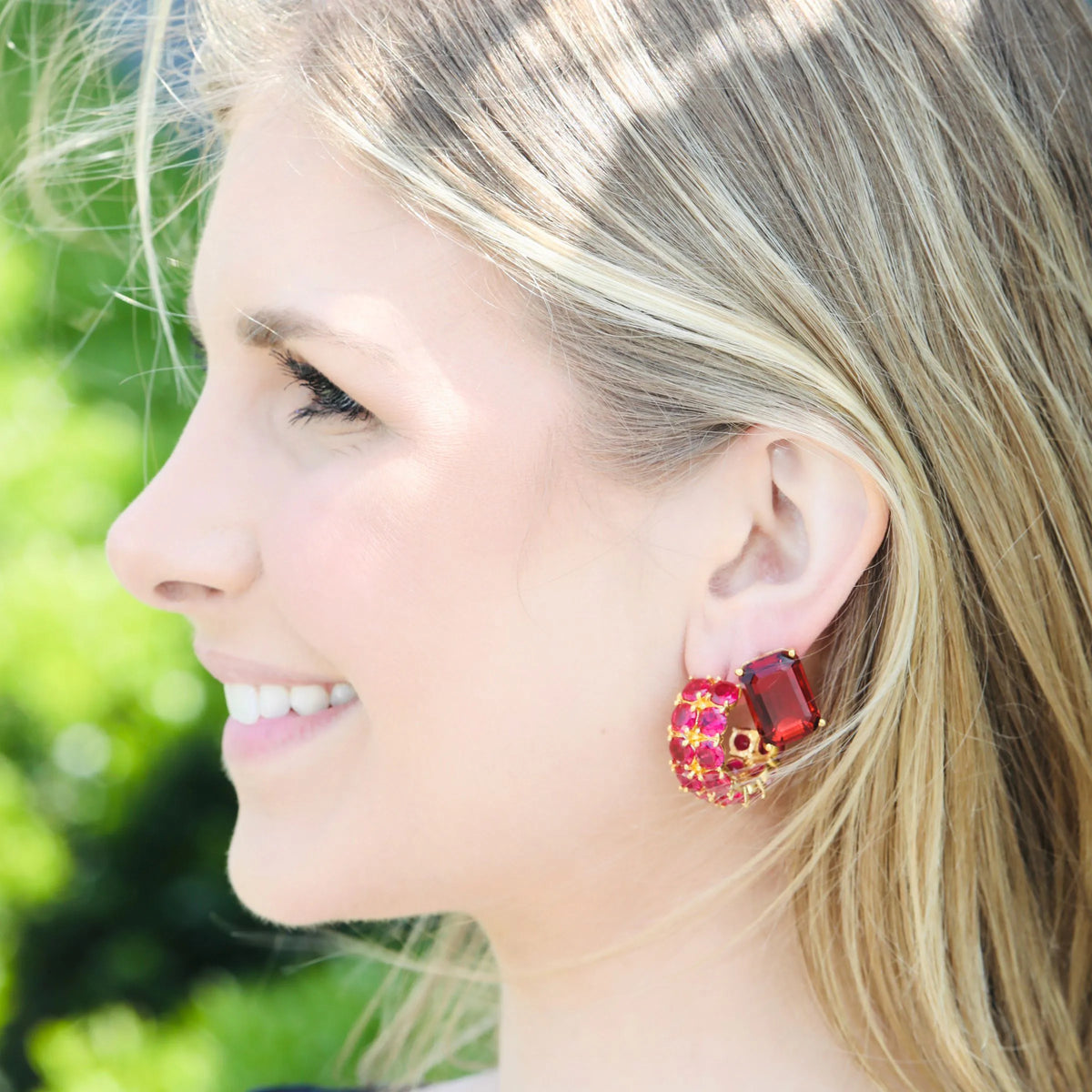 Ruby dangle earrings worn on the ear along with red garnet stud earrings. we call this pairing of gilded glamour hoop earrings with stud earrings as glamour cascade