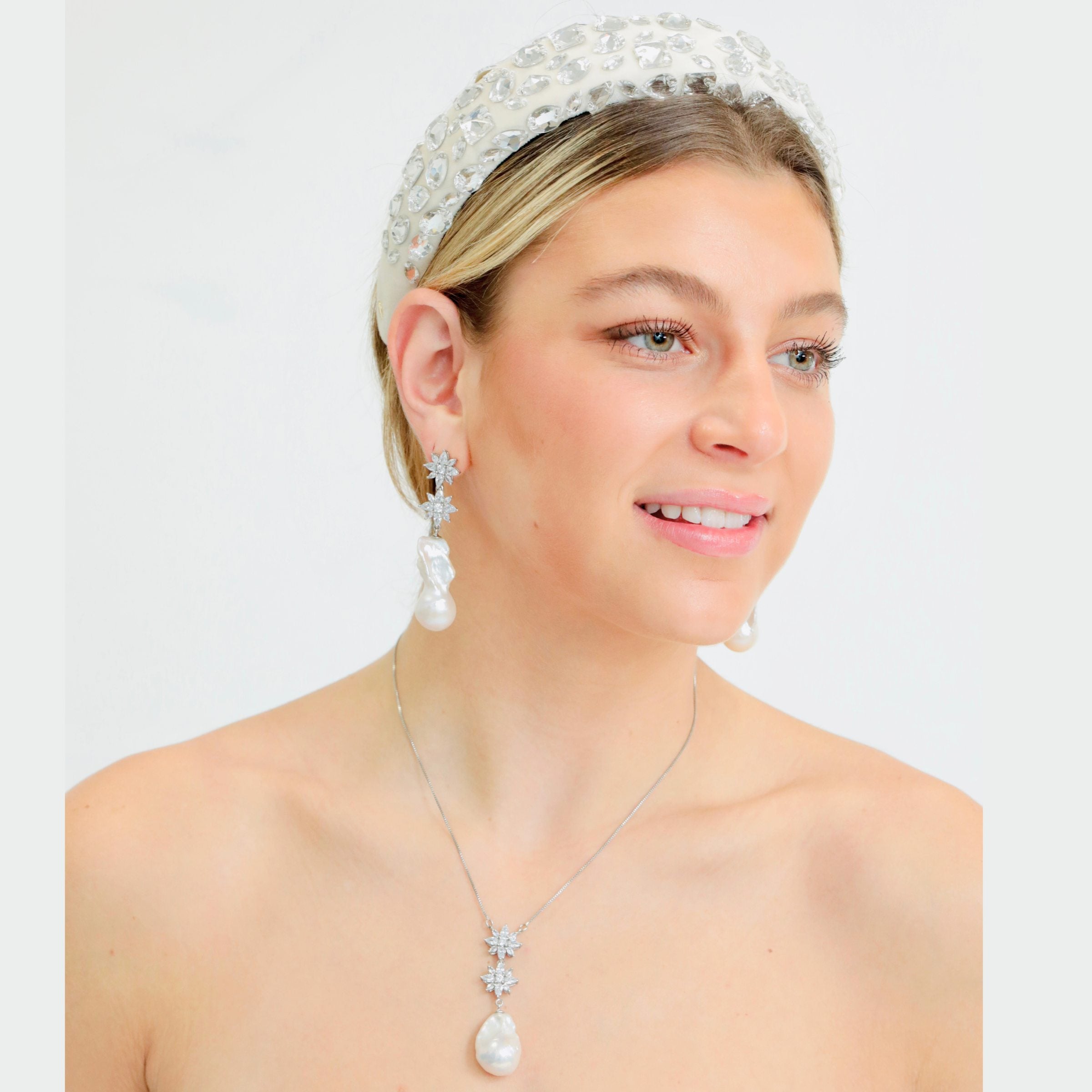 A close-up of the cz diamond flower detailing shared by this freshwater cultured pearl necklace and its matching earrings.